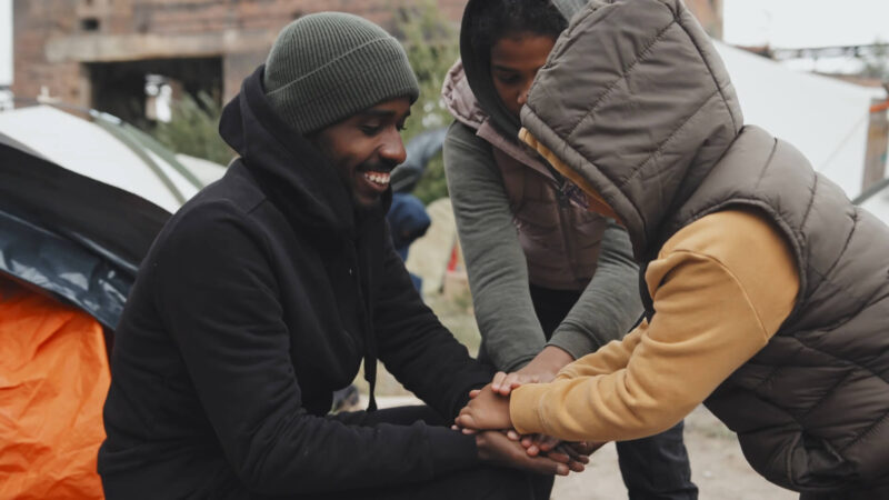 A young man entertaining refugee children