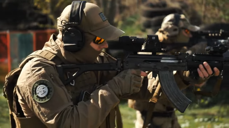 Tactical Training Session with Two Participants Aiming Rifles Equipped with Scopes in An Outdoor Range