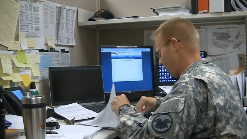 A Military Officer in Uniform Working at A Desk, Reviewing Paperwork Related to DA Form 5960 Submission for Military Housing Support