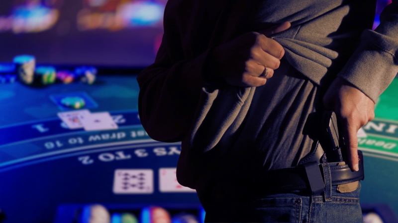 Person Adjusting a Concealed Firearm at A Casino Table