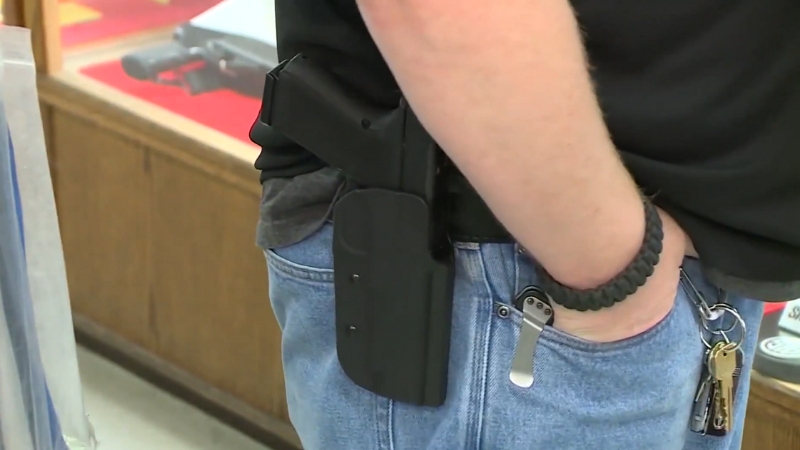 A Person in Jeans Carrying a Handgun in A Holster