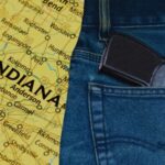 A Handgun Partially Visible in A Jeans Pocket Next to A Map of Indiana, Representing Indiana’s Concealed Carry Laws