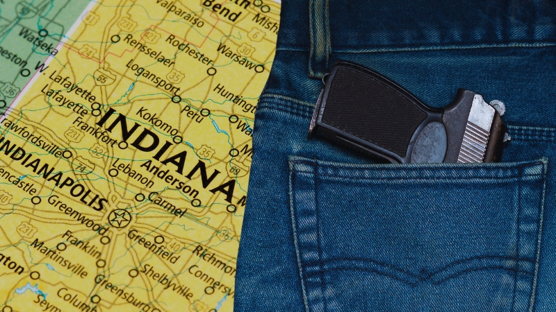 A Handgun Partially Visible in A Jeans Pocket Next to A Map of Indiana, Representing Indiana’s Concealed Carry Laws