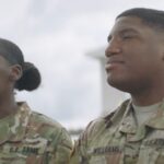 Two Military Personnel in Uniform, Discussing Their Experience with Military Housing Support Outside a Residential Building