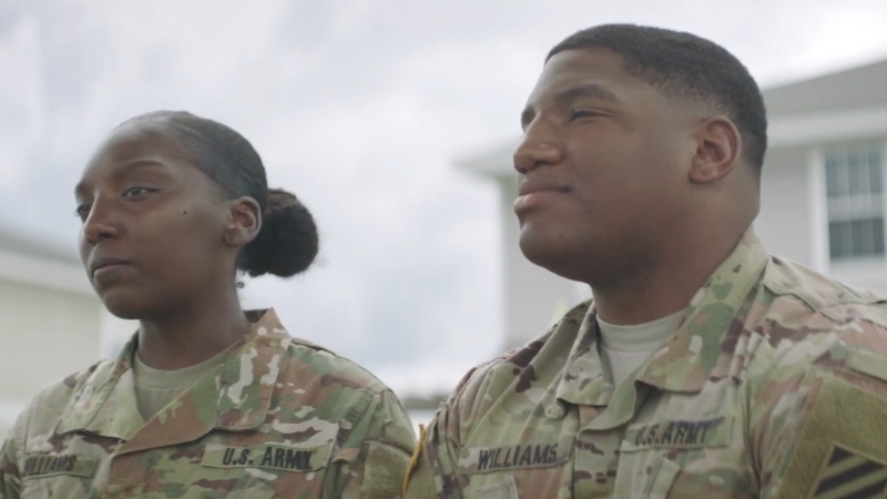 Two Military Personnel in Uniform, Discussing Their Experience with Military Housing Support Outside a Residential Building