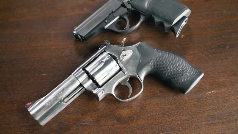 Two Types of Firearms Displayed on A Wooden Surface, a Revolver and A Semi-Automatic Pistol