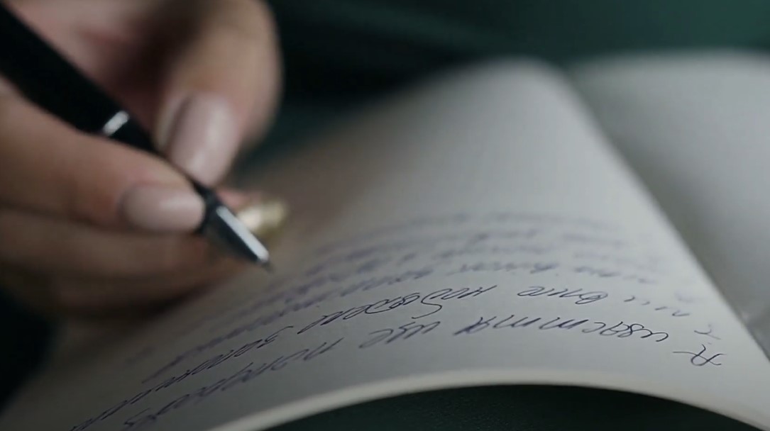 Close-up of a hand writing in a dream journal