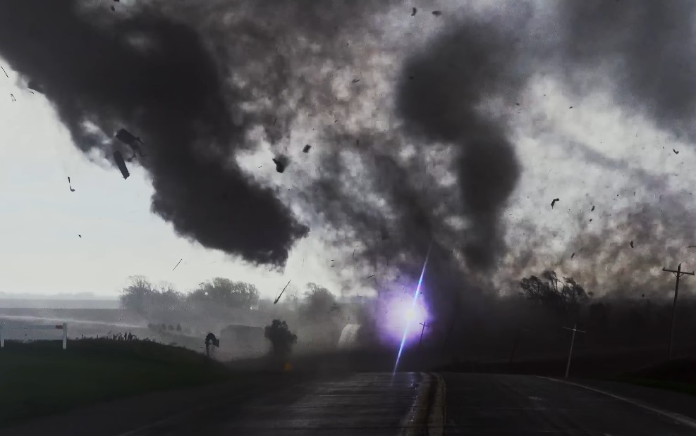 A powerful tornado rips across the landscape, debris swirling violently